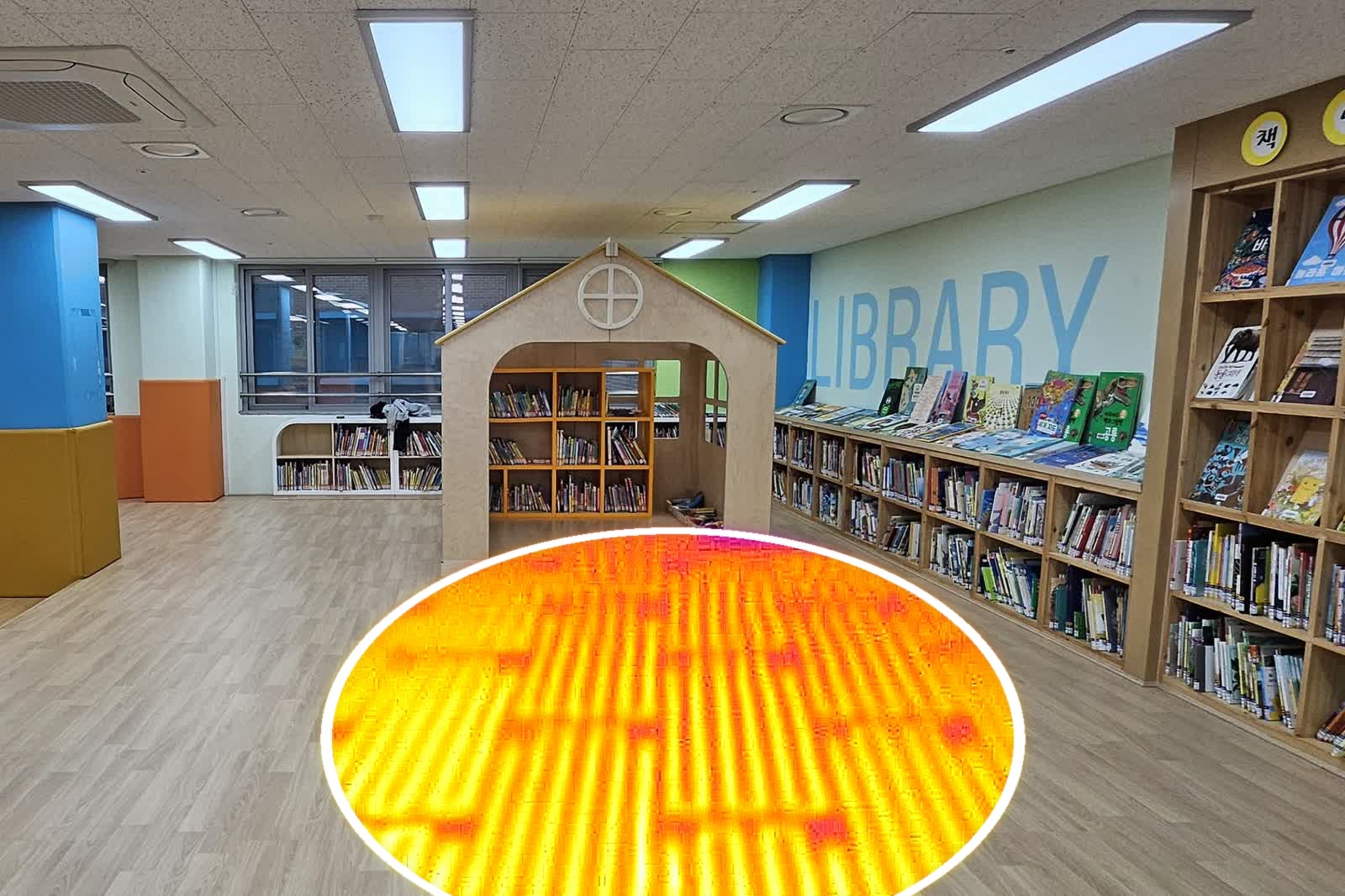 인천서희학교 도서실에 시공한 전기온돌 강화마루 — 바닥 일부를 타원형으로 열화상 처리해 바닥 속 전열선 배치가 드러난다